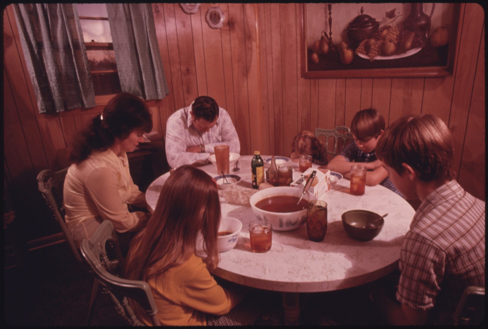 Família rezando antes do jantar em casa, fotografia documental dos anos 70